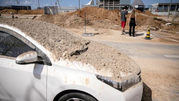 People look at a crater that was later filled in by municipal workers and was caused when Iran fired a salvo of ballistic missiles at Israel, in Tel Aviv, Israel, October 2, 2024. REUTERS/Nir Elias