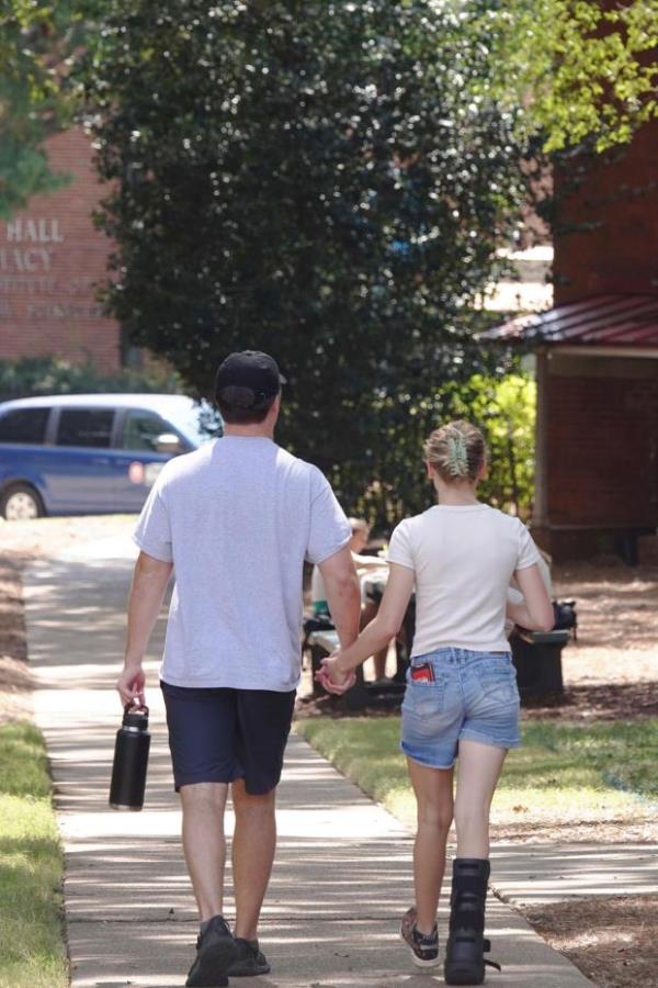 A couple holds hands at the University of Mississippi campus