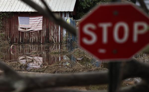 An American flag is reflected in floodwaters remaining from Hurricane Helene on October 4, 2024 in Swannanoa, North Carolina.