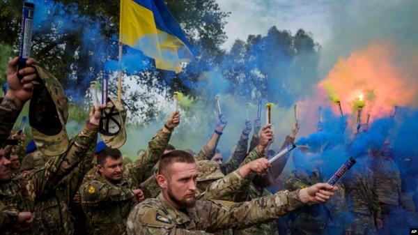 Ukrainian servicemen of the Azov brigade light flares during the funeral ceremony of a fallen comrade in Travkine, Chernihiv region, Ukraine, Oct. 4, 2024. 