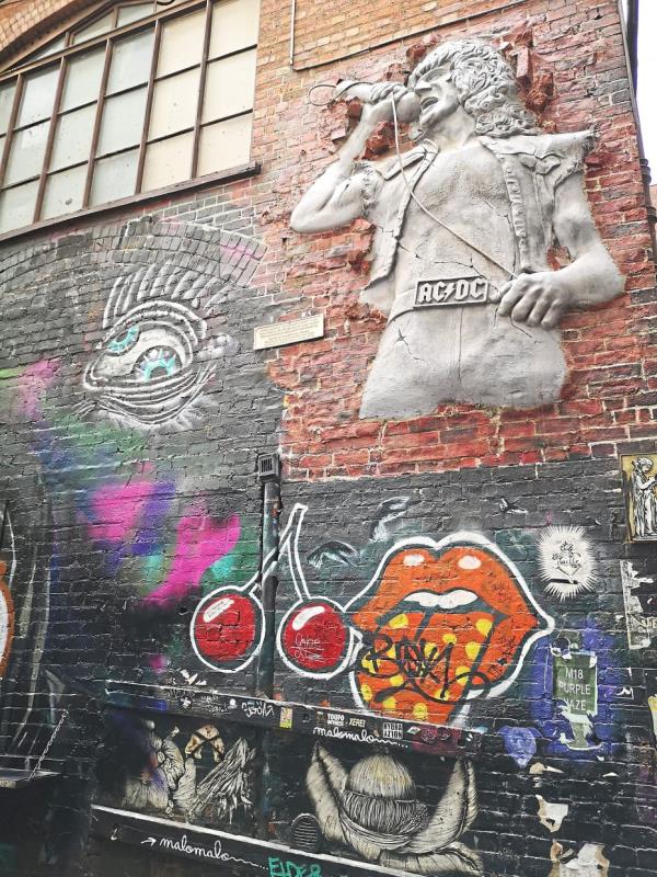 Graffiti and an AC/DC sculpture seen on the wall of one of the laneways in Melbourne.