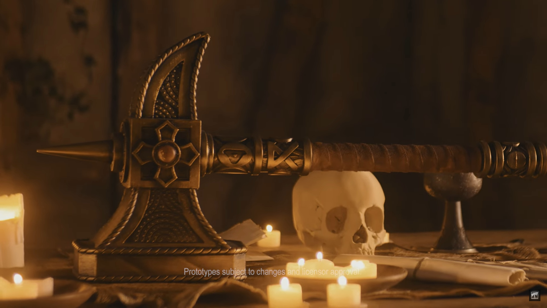 Ghal Maraz replica on a candlelit surface, beside a skull