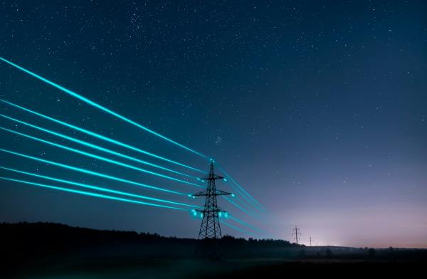 Electricity pylons with glowing wires in night sky